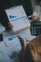 Financial analysts analyze business financial reports on a digital tablet planning investment project during a discussion at a meeting of corporate showing the results of their successful teamwork. photo