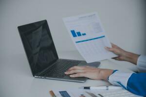 Financial analysts analyze business financial reports on a digital tablet planning investment project during a discussion at a meeting of corporate showing the results of their successful teamwork. photo