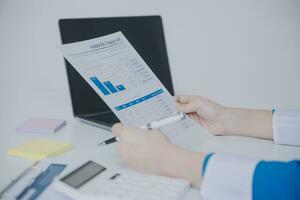 Financial analysts analyze business financial reports on a digital tablet planning investment project during a discussion at a meeting of corporate showing the results of their successful teamwork. photo