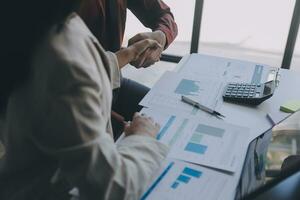 Financial analysts analyze business financial reports on a digital tablet planning investment project during a discussion at a meeting of corporate showing the results of their successful teamwork. photo