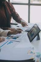 Financial analysts analyze business financial reports on a digital tablet planning investment project during a discussion at a meeting of corporate showing the results of their successful teamwork. photo