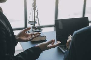 Business and lawyers discussing contract papers with brass scale on desk in office. Law, legal services, advice, justice and law concept picture with film grain effect photo