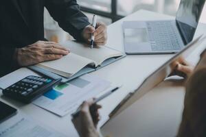 Financial analysts analyze business financial reports on a digital tablet planning investment project during a discussion at a meeting of corporate showing the results of their successful teamwork. photo