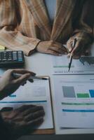 Financial analysts analyze business financial reports on a digital tablet planning investment project during a discussion at a meeting of corporate showing the results of their successful teamwork. photo