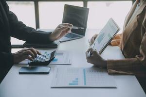 Financial analysts analyze business financial reports on a digital tablet planning investment project during a discussion at a meeting of corporate showing the results of their successful teamwork. photo