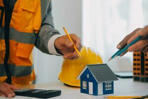 Construction and structure concept of Engineer or architect meeting for project working with partner and engineering tools on model building and blueprint in working site, contract for both companies. photo