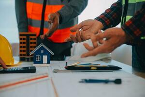Construction and structure concept of Engineer or architect meeting for project working with partner and engineering tools on model building and blueprint in working site, contract for both companies. photo