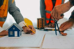 Construction and structure concept of Engineer or architect meeting for project working with partner and engineering tools on model building and blueprint in working site, contract for both companies. photo