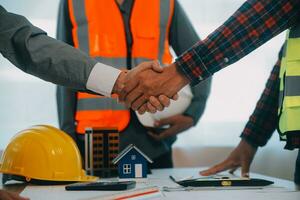 Construction and structure concept of Engineer or architect meeting for project working with partner and engineering tools on model building and blueprint in working site, contract for both companies. photo