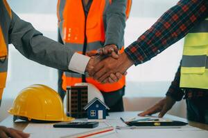 Construction and structure concept of Engineer or architect meeting for project working with partner and engineering tools on model building and blueprint in working site, contract for both companies. photo