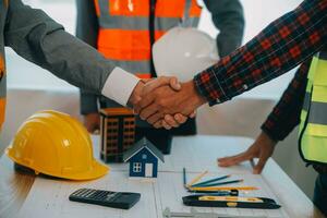 Construction and structure concept of Engineer or architect meeting for project working with partner and engineering tools on model building and blueprint in working site, contract for both companies. photo