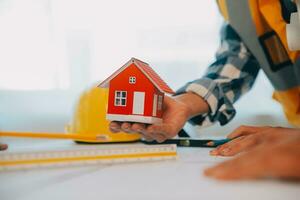 Construction and structure concept of Engineer or architect meeting for project working with partner and engineering tools on model building and blueprint in working site, contract for both companies. photo