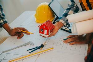 Construction and structure concept of Engineer or architect meeting for project working with partner and engineering tools on model building and blueprint in working site, contract for both companies. photo