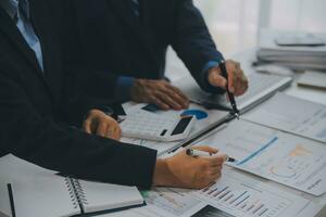 Financial analysts analyze business financial reports on a digital tablet planning investment project during a discussion at a meeting of corporate showing the results of their successful teamwork. photo