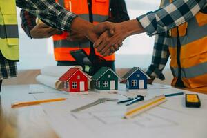 Construction and structure concept of Engineer or architect meeting for project working with partner and engineering tools on model building and blueprint in working site, contract for both companies. photo