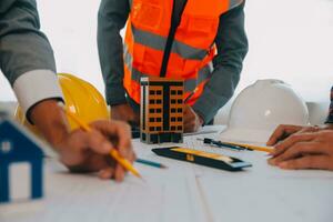 Construction and structure concept of Engineer or architect meeting for project working with partner and engineering tools on model building and blueprint in working site, contract for both companies. photo
