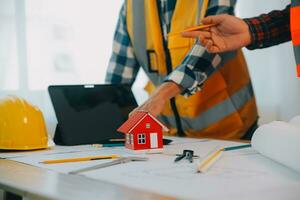 Construction and structure concept of Engineer or architect meeting for project working with partner and engineering tools on model building and blueprint in working site, contract for both companies. photo