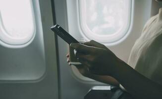 Asian woman enjoying enjoys a coffee comfortable flight while sitting in the airplane cabin, Passengers near the window. photo