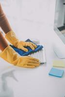 Office Cleaning Service. Janitor Spraying Desk. Workplace Hygiene photo