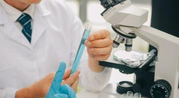 Scientist or medical in lab coat working in biotechnological laboratory, Microscope equipment for research with mixing reagents in glass flask in clinical laboratory. photo