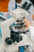 científico o médico en laboratorio Saco trabajando en biotecnológico laboratorio, microscopio equipo para investigación con mezcla reactivos en vaso matraz en clínico laboratorio. foto