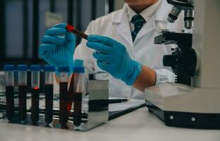 Scientist or medical in lab coat working in biotechnological laboratory, Microscope equipment for research with mixing reagents in glass flask in clinical laboratory. photo