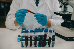 Scientist or medical in lab coat working in biotechnological laboratory, Microscope equipment for research with mixing reagents in glass flask in clinical laboratory. photo