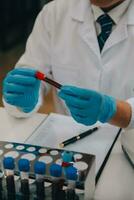 Scientist or medical in lab coat working in biotechnological laboratory, Microscope equipment for research with mixing reagents in glass flask in clinical laboratory. photo