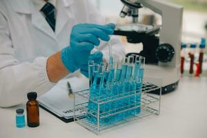 Scientist or medical in lab coat working in biotechnological laboratory, Microscope equipment for research with mixing reagents in glass flask in clinical laboratory. photo