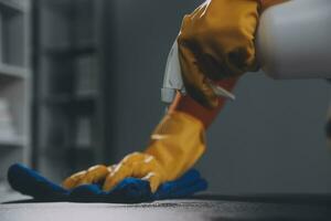 Office Cleaning Service. Janitor Spraying Desk. Workplace Hygiene photo