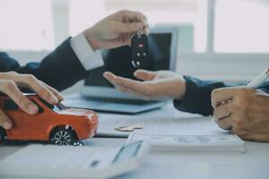 Closeup asian male people car salesman or sales manager offers to sell a car and explains and reads the terms of signing a car contract and insurance. photo