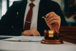 Business and lawyers discussing contract papers with brass scale on desk in office. Law, legal services, advice, justice and law concept picture with film grain effect photo