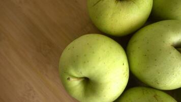 Grün Äpfel dreht sich im hölzern Hintergrund video