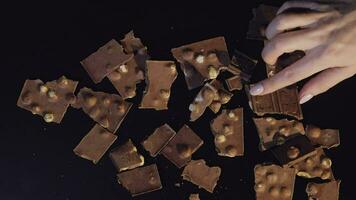 Frau Hand nimmt Stück von Schokolade von ein Bündel von Schokolade Stücke video