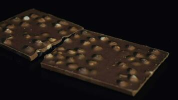 Dark chocolate blocks with nuts details slow close-up macro. Chocolate bars video