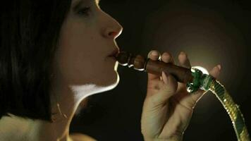 mooi, jong vrouw roken hookah. aantrekkelijk meisje roken gearomatiseerd tabak video