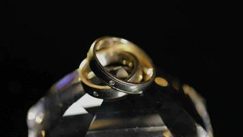 Wedding rings lying on crystal shining with light close up macro video