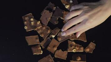 mujer mano toma pedazo de chocolate desde un manojo de chocolate piezas video