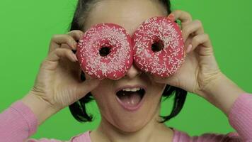 gelukkig mooi jong meisje poseren en hebben pret met donuts. chroma sleutel video