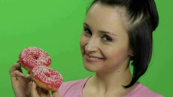 Happy beautiful young girl posing and having fun with donuts. Chroma key video