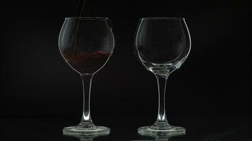 Rose du vin. rouge du vin verser dans deux du vin des lunettes plus de noir Contexte. silhouette video