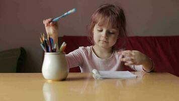 Cute child girl artist studying drawing picture with pen and pencils at home video