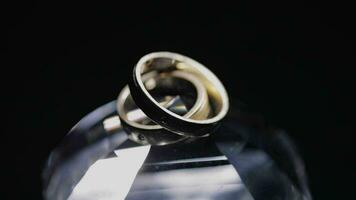 Wedding rings lying on crystal shining with light close up macro video