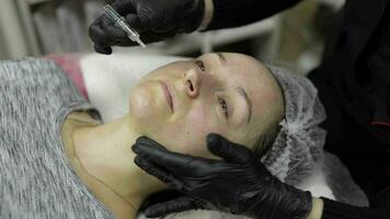 Cosmetologist applies peeling lotion on woman face in beauty clinic salon video