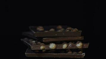 Dark chocolate blocks with nuts details slow close-up macro. Chocolate bars video