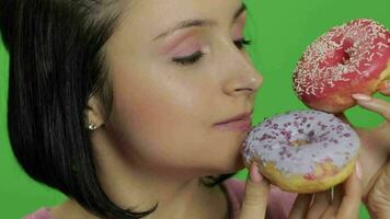 Happy beautiful young girl posing and having fun with donuts. Chroma key video