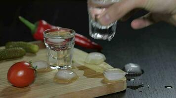 Mens zet een glas gevulde met wodka Aan de houten bord video