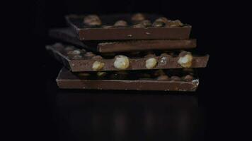 Dark chocolate blocks with nuts details slow close-up macro. Chocolate bars video