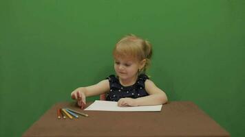 menina sentado às a mesa. Educação processo. fofa menina sorridente. croma chave video