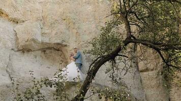 Casamento casal em pé juntos em uma lado da montanha. recém-casados. noivo e noiva video